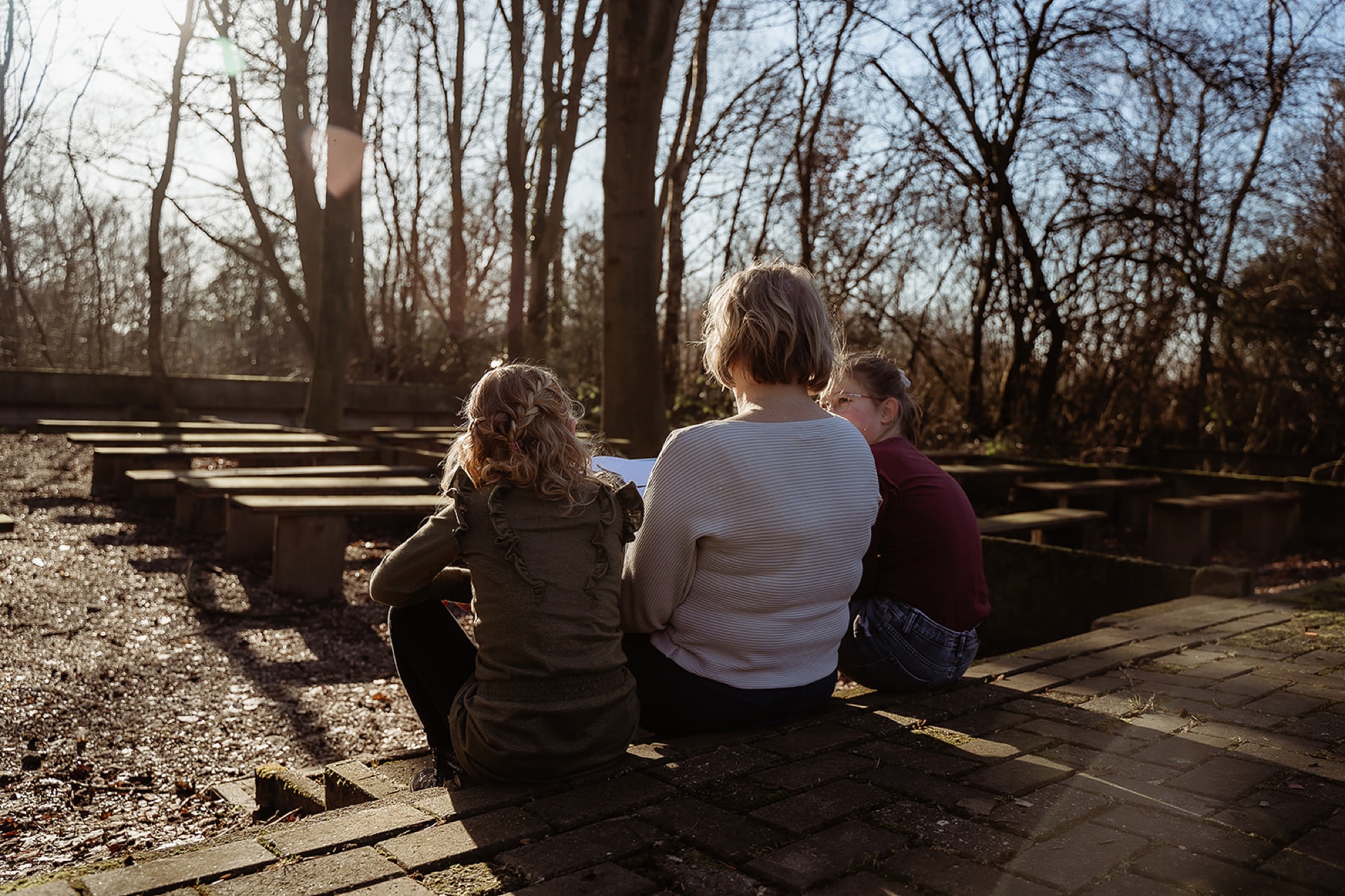 Begeleider in gesprek met twee kinderen in de buitenlucht