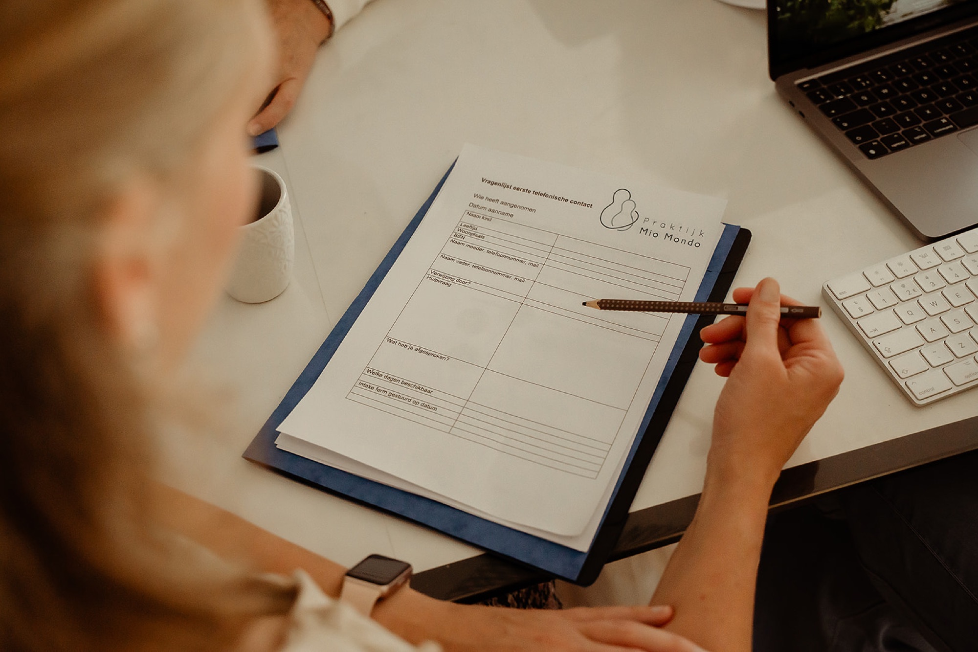 Begeleider maakt notities op het intakeformulier van Praktijk Mio Mondo