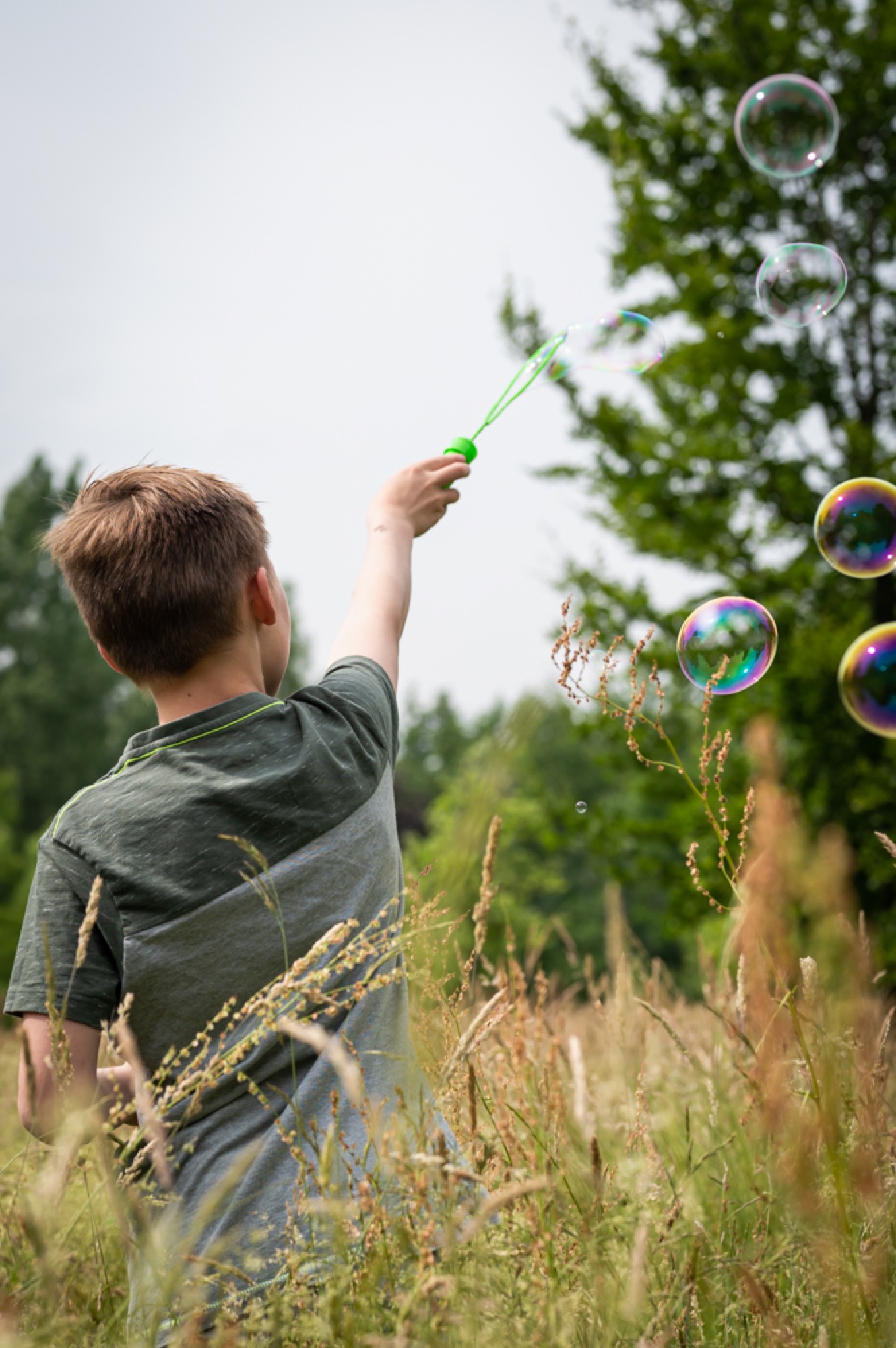 Kind blaast bellen tijdens een activiteit in de natuur